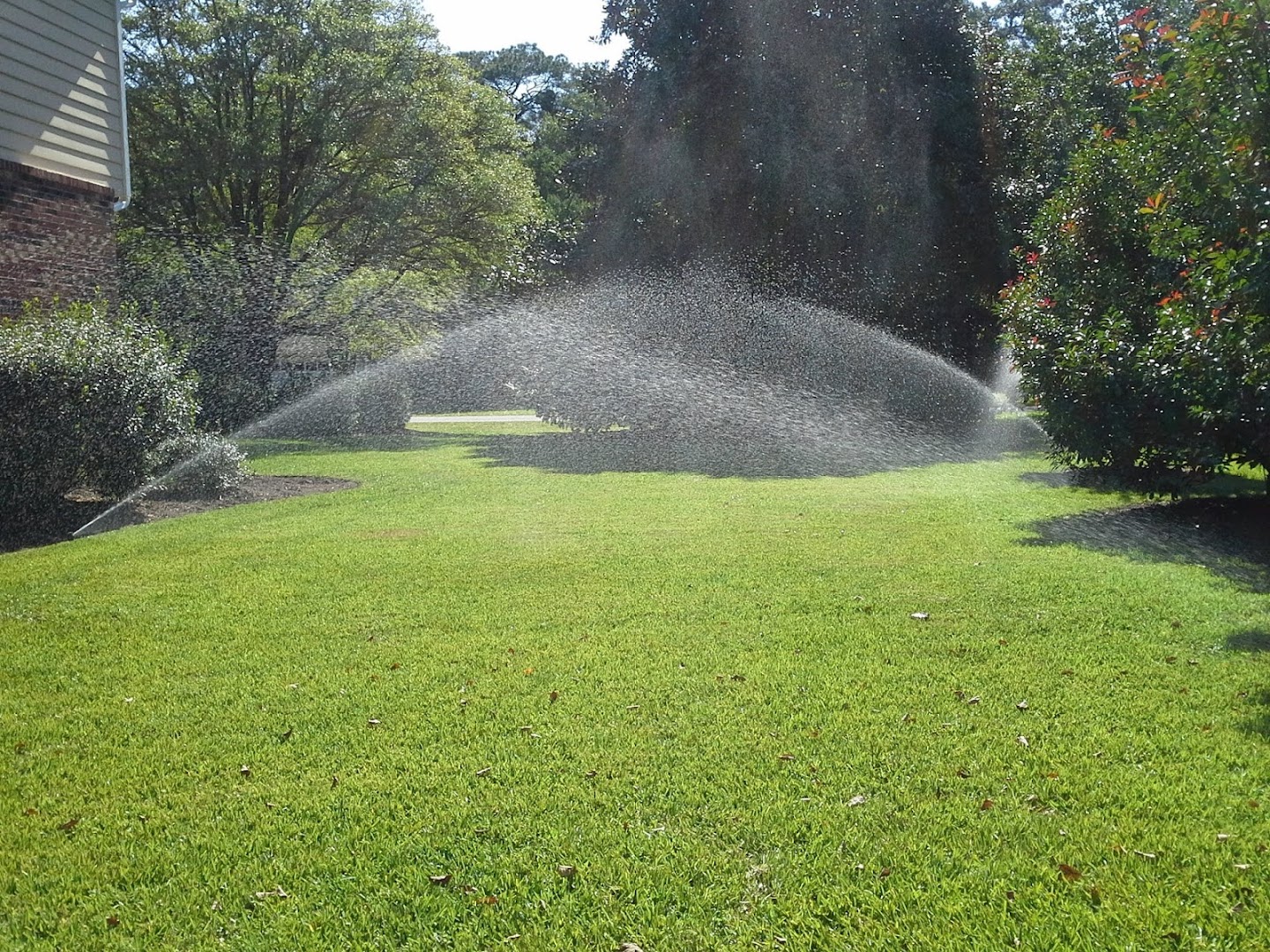 Irrigation sprinkler running on a lush green lawn, Wilmington NC